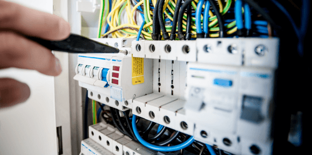 En la imagen se ve un electricista de instalaciones y reparaciones zuar arreglando un cuadro electrico